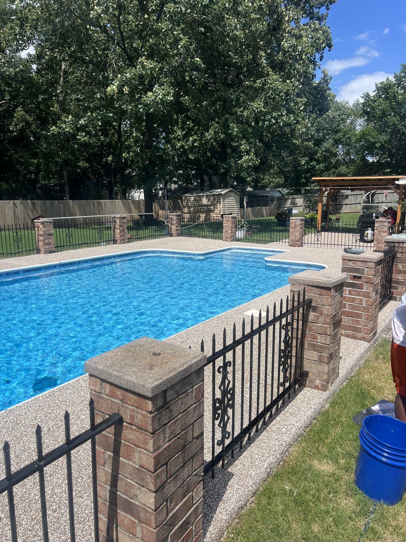 Finished Brownstone pool deck around a bright blue pool in Cabot