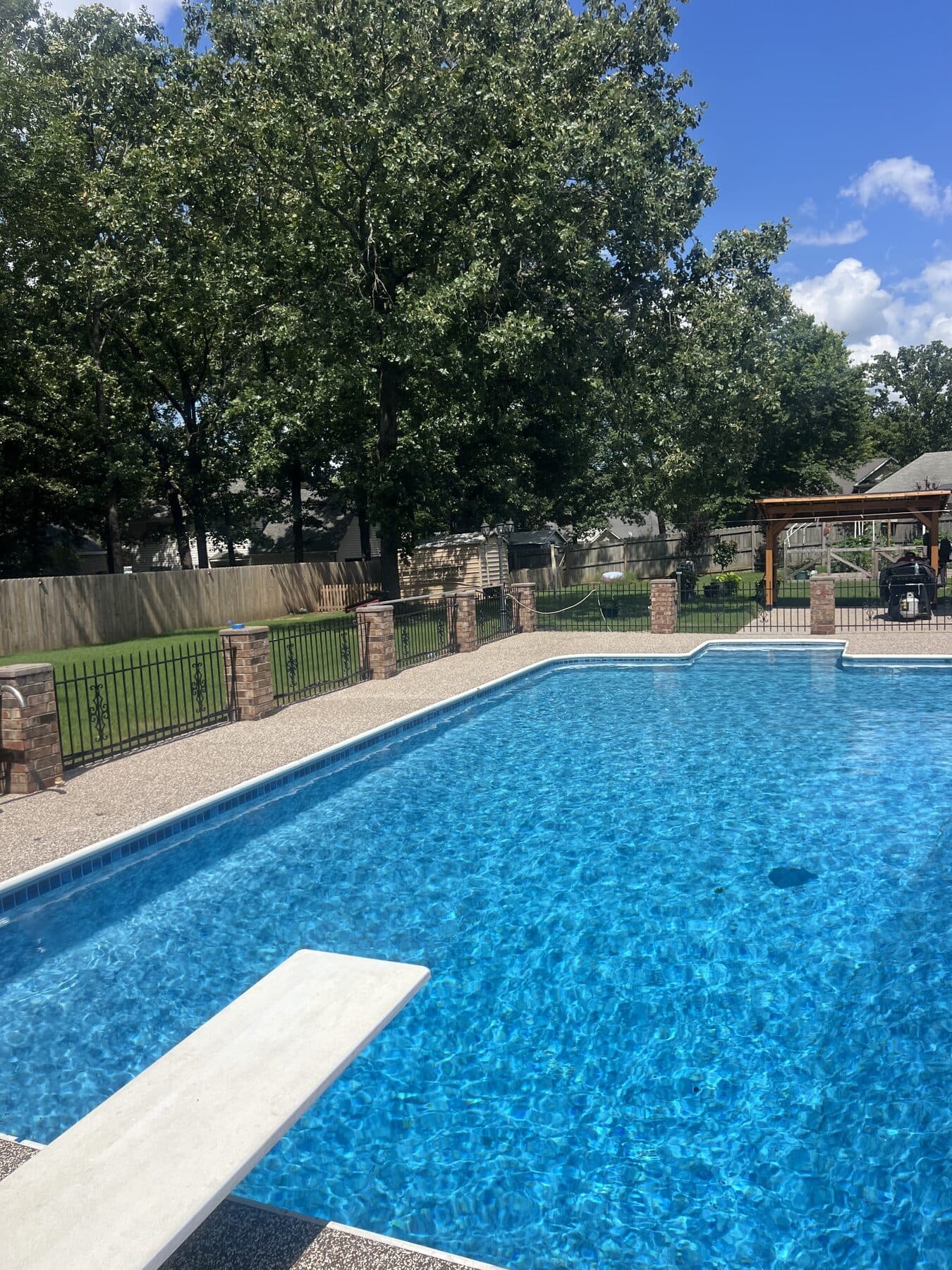 Finished Brownstone pool deck with brick columns in Cabot