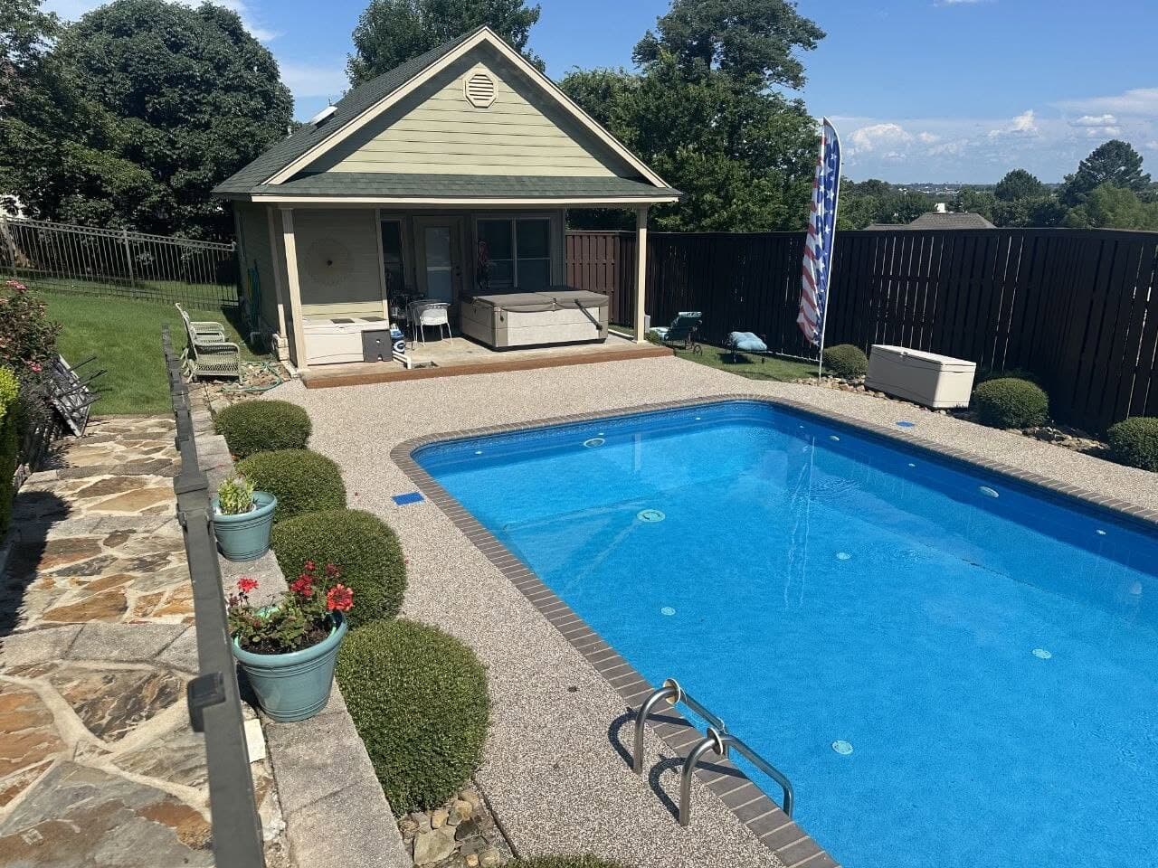 Finished Brownstone pool deck beside a bright blue pool in Fort Smith