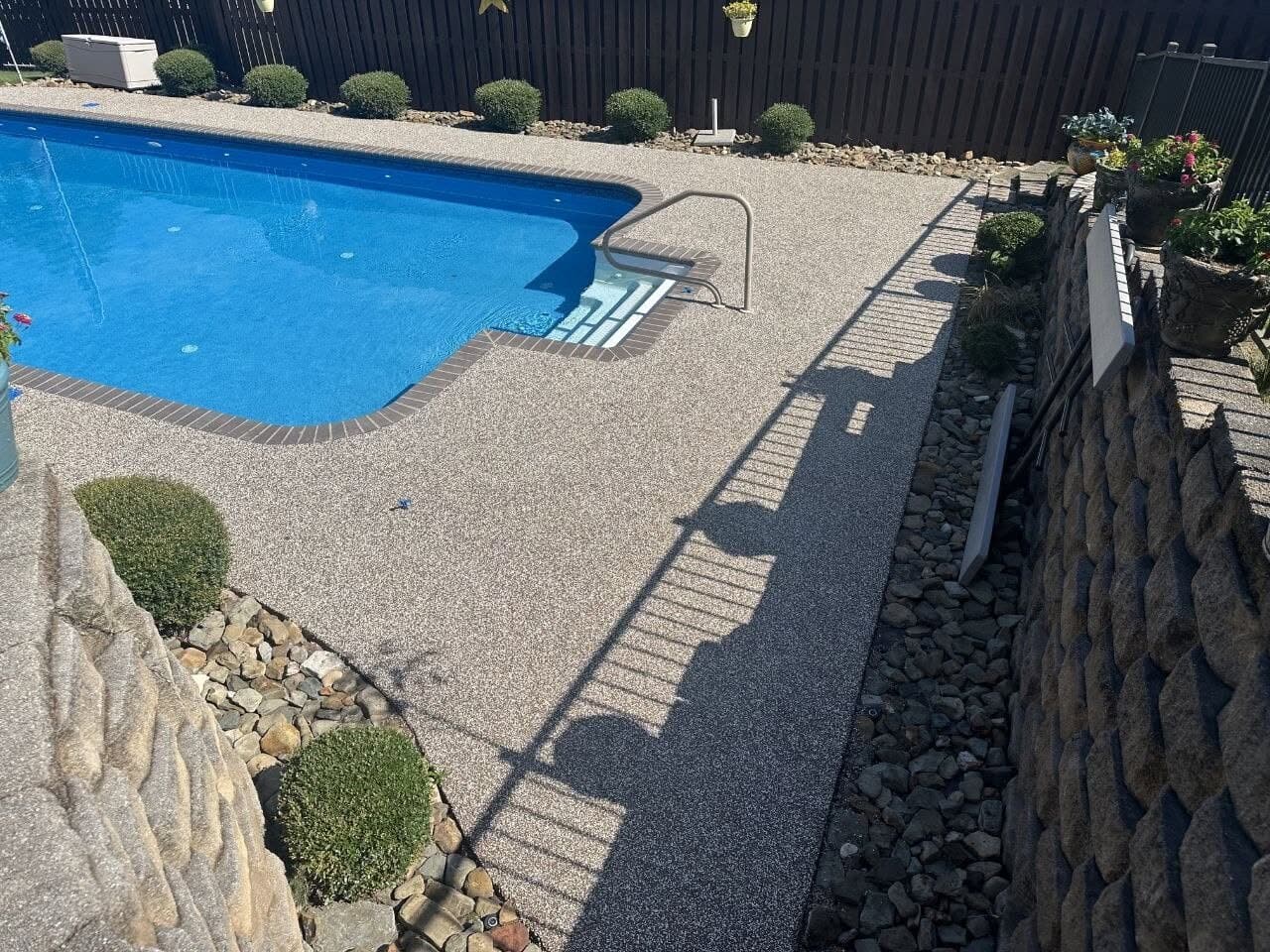 Finished Brownstone pool deck beside natural stone in Fort Smith