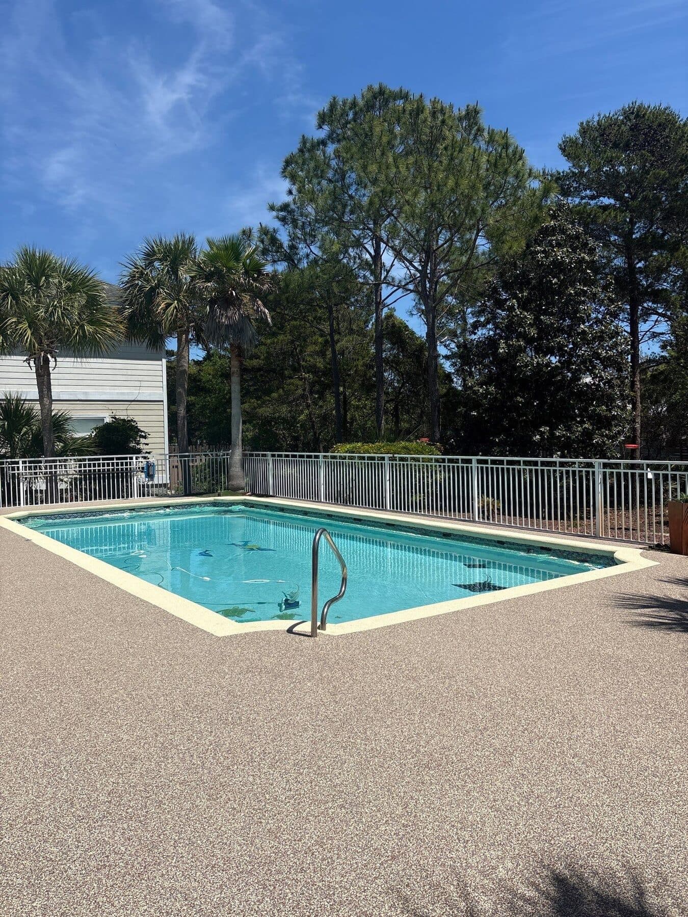 Finished light neutral pool deck with resort-style landscaping