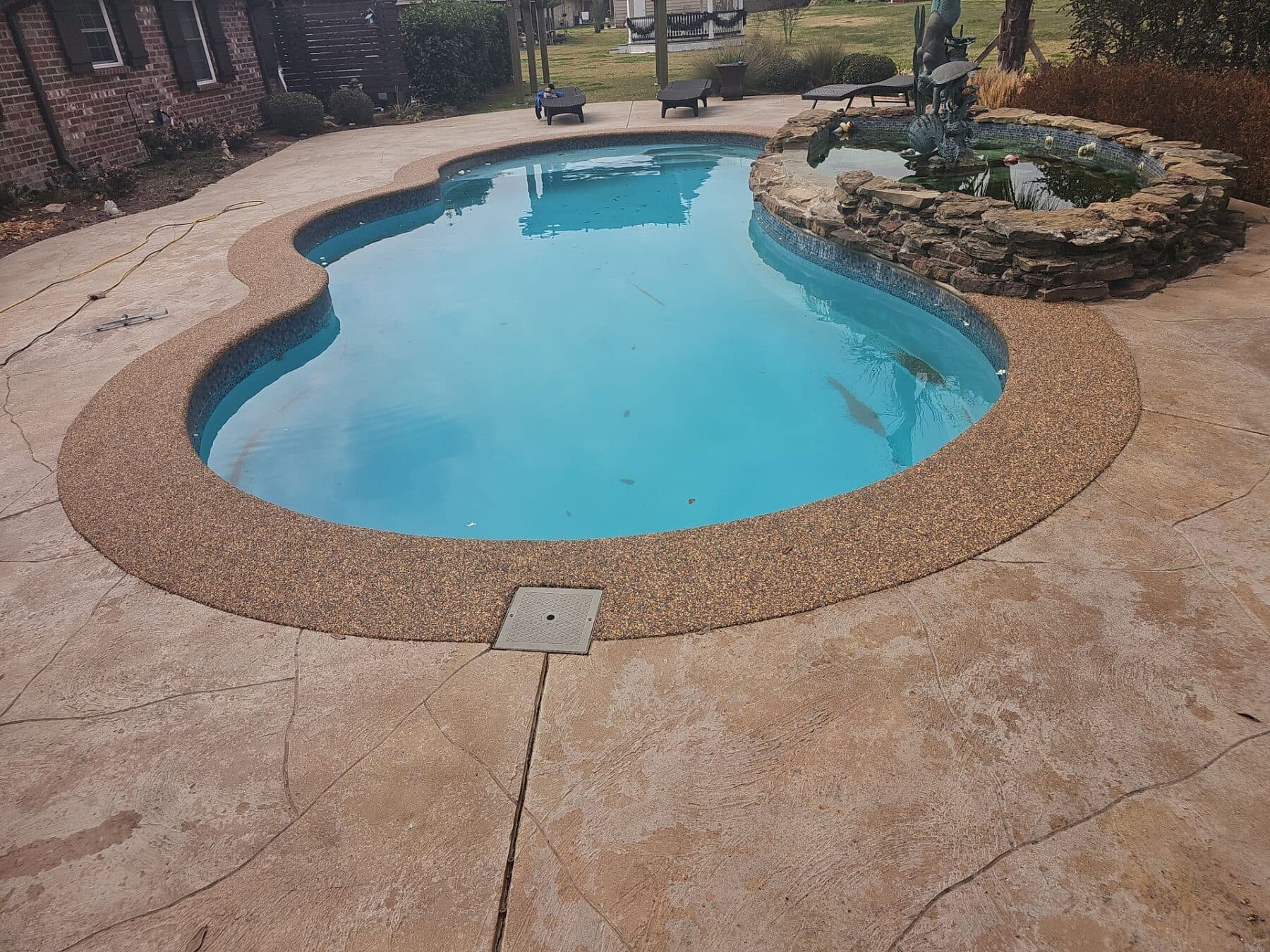 Finished Sandstone surface around a curved backyard pool
