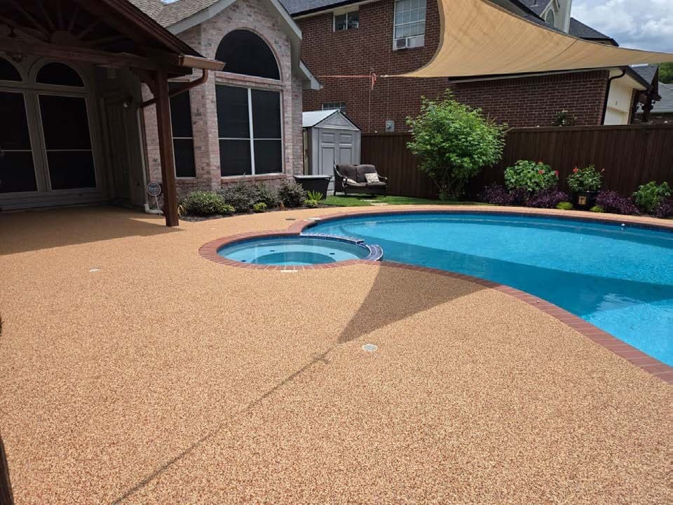 Finished warm-toned pool deck around a backyard pool