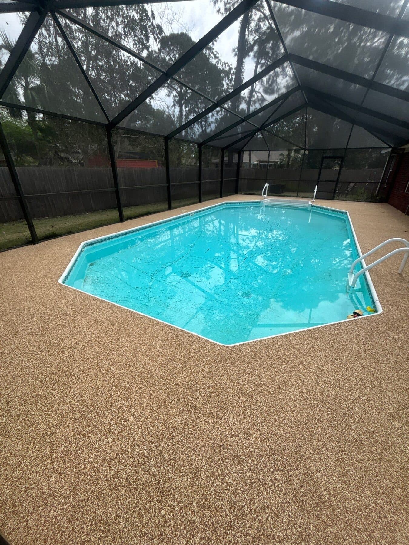 Finished warm neutral pool deck inside a bright screened enclosure