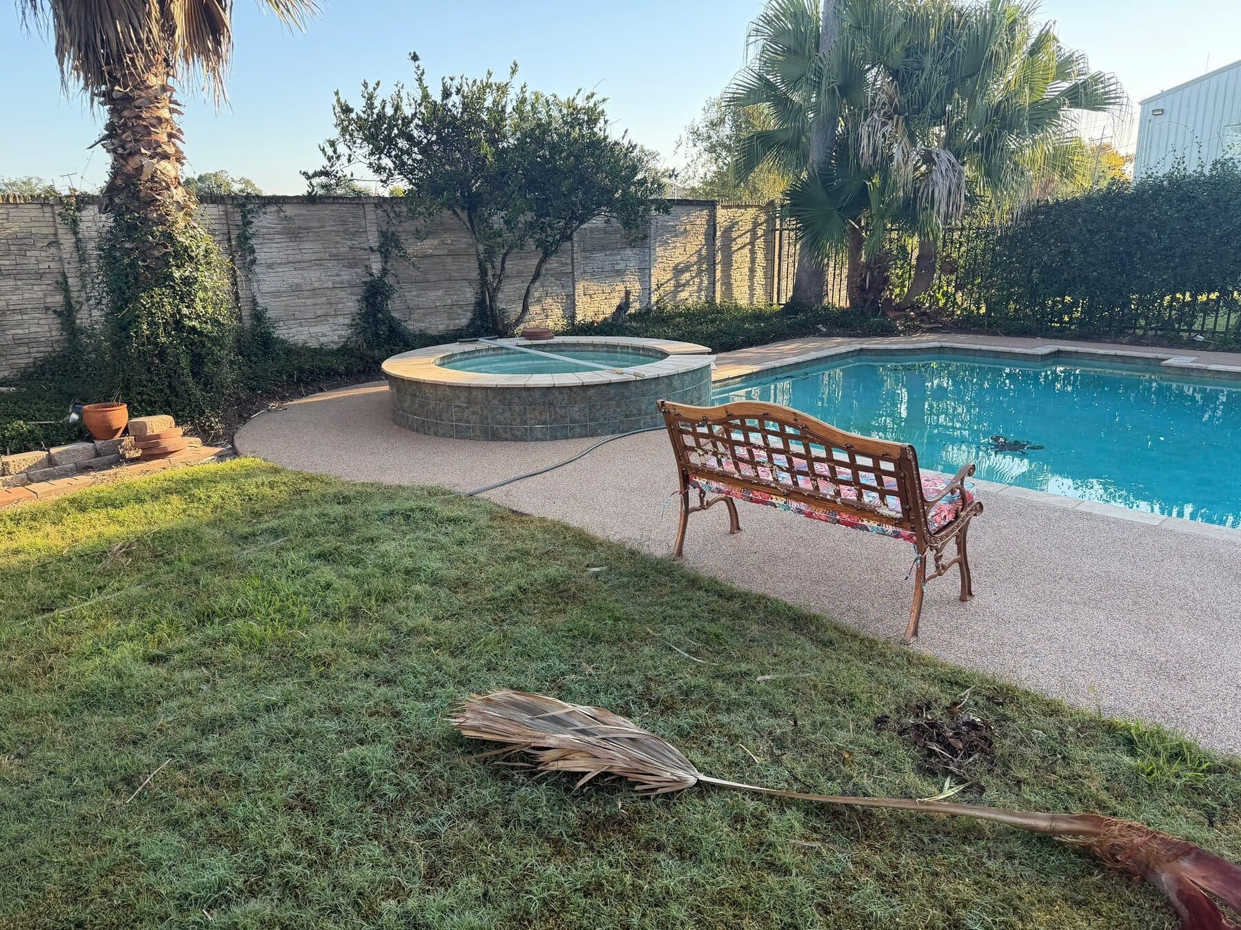 Finished warm pool deck surrounding a pool and raised spa