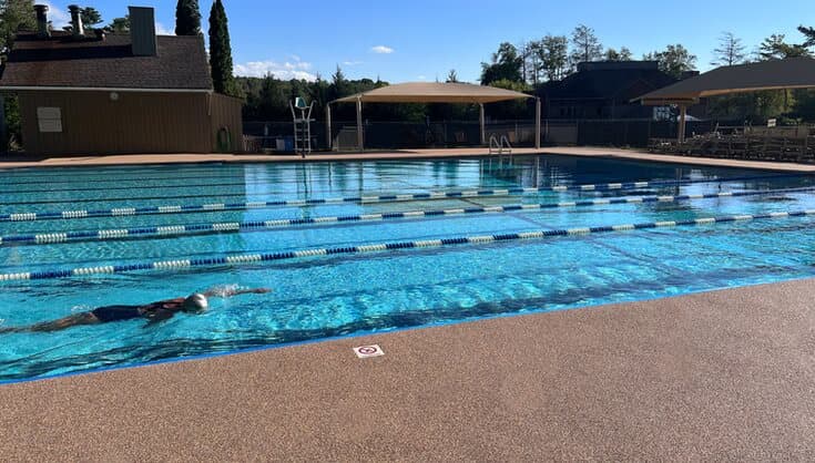 Warm-toned Rubaroc surface around a competition pool