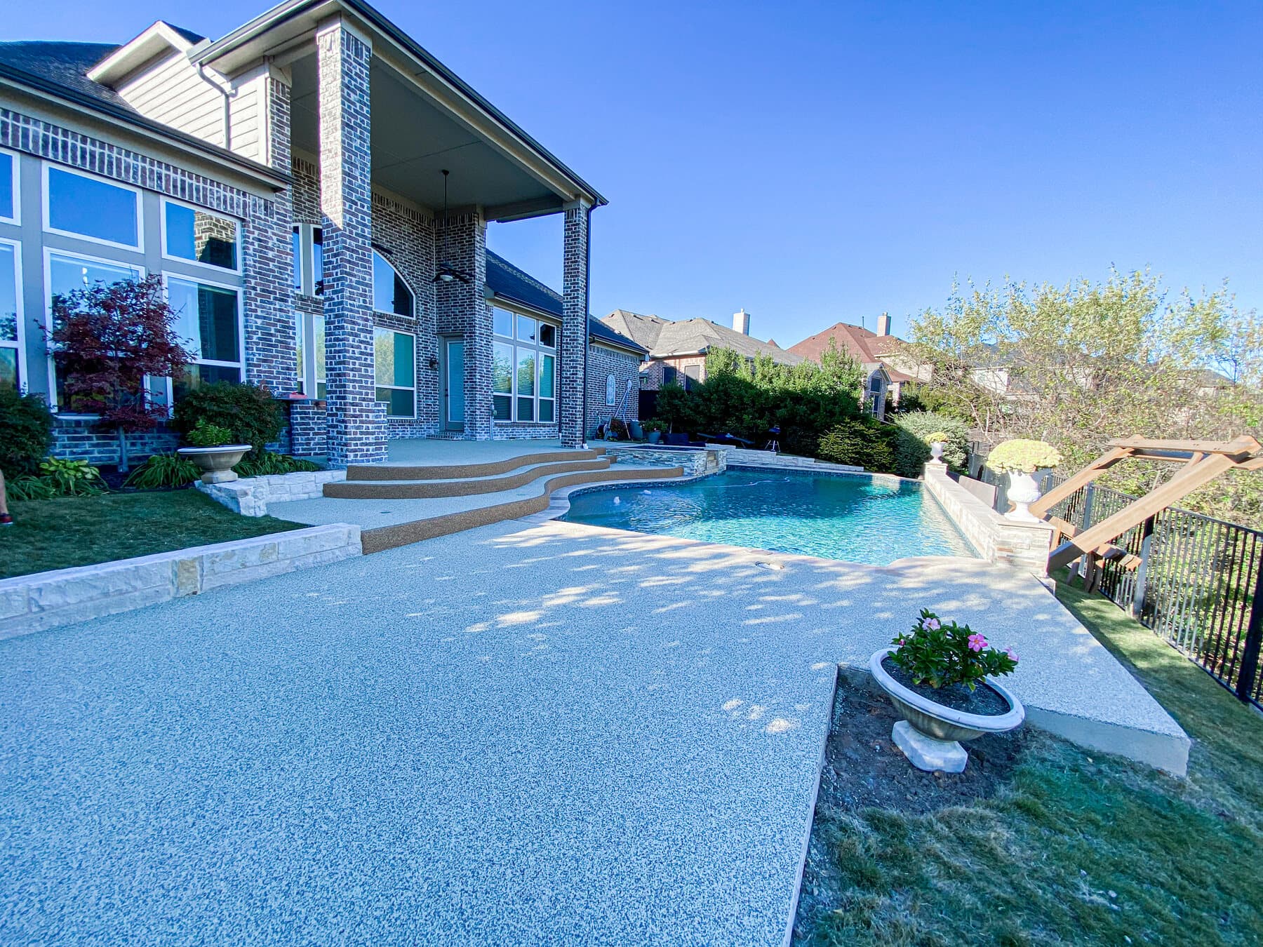 Rubaroc pool deck installation at a landscaped residence