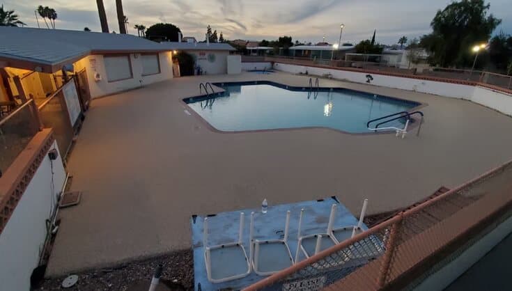 Light Rubaroc pool deck surrounding a pool at twilight