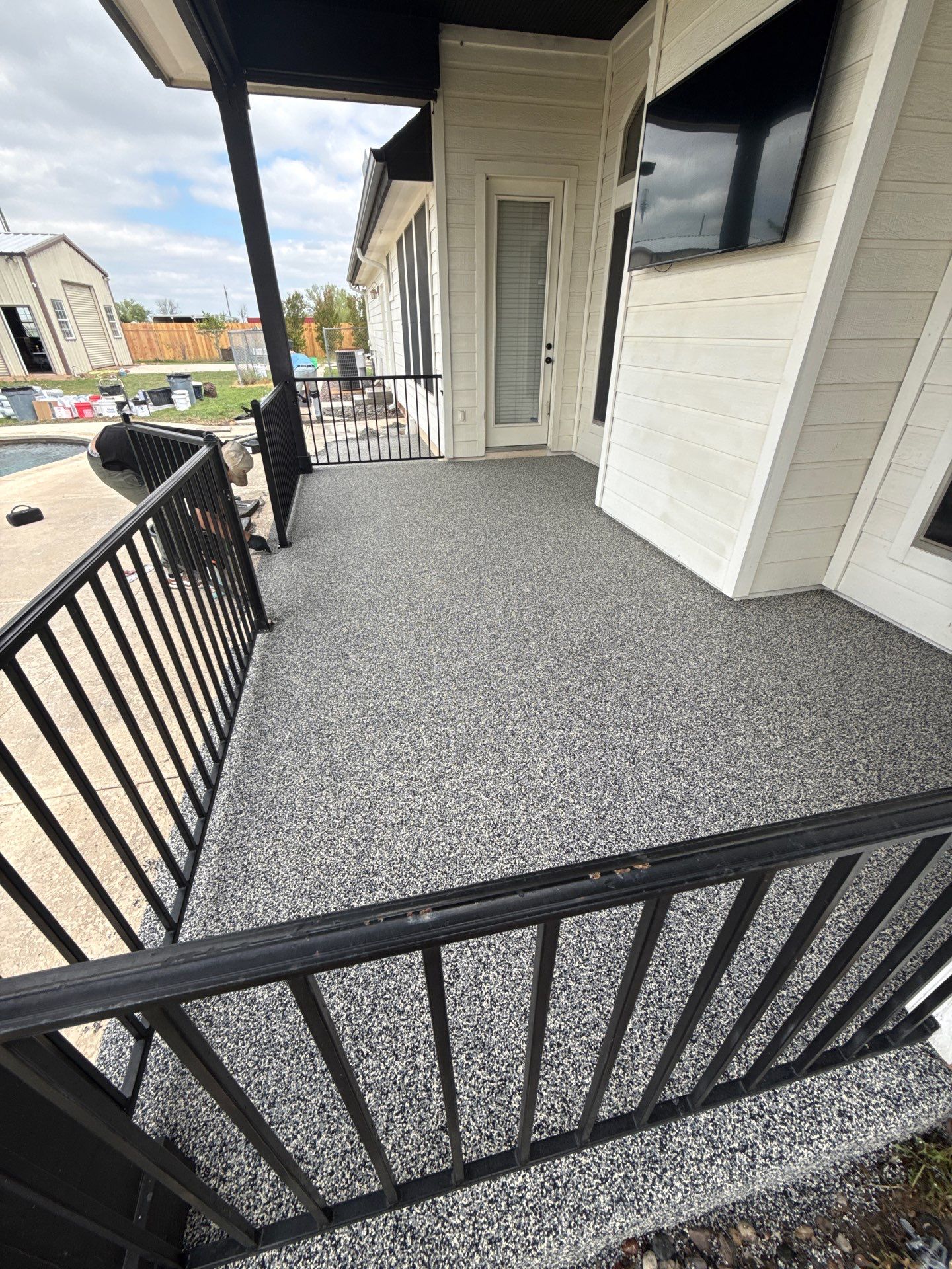 A cracked patio in Little Rock covered with a hand-troweled rubber finish, no demolition